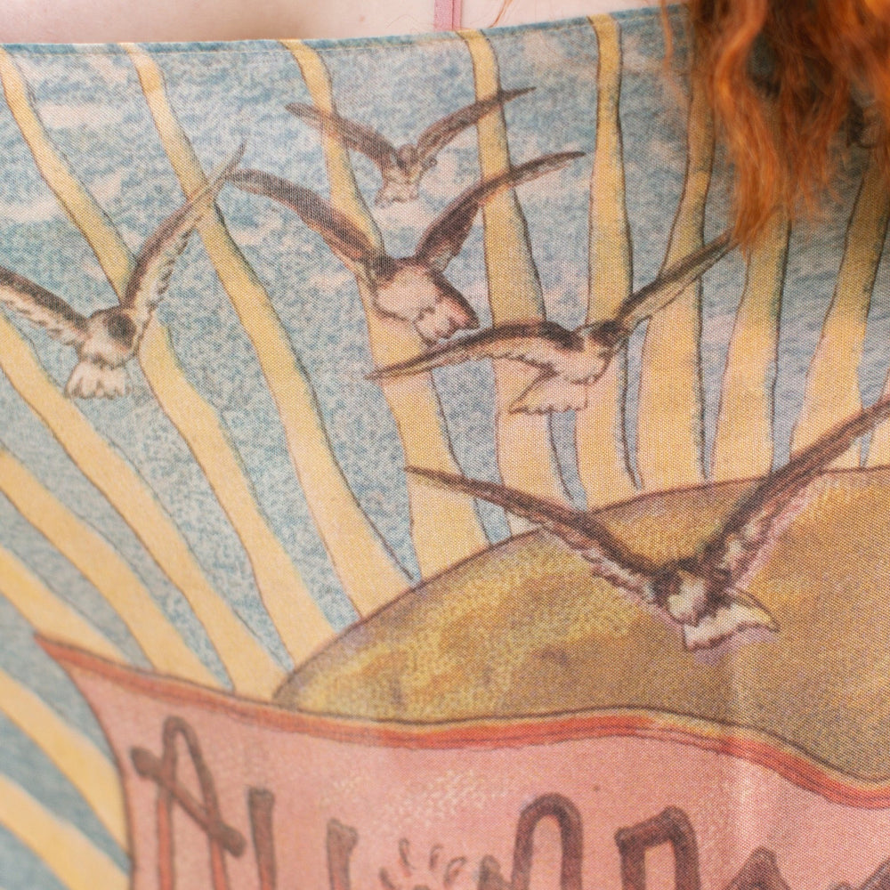 
                  
                    Lightweight scarf featuring a dreamy sunrise landscape and nautical artwork with the words "All aboard for Sunrise Lands" – Market of Stars
                  
                