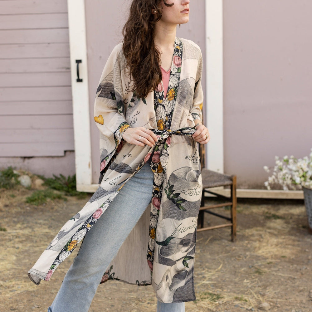
                  
                    Clasped hands, radiant sun rays, and blooming florals in a joyful Victorian collage on our full-length Take My Hand Opera Duster
                  
                