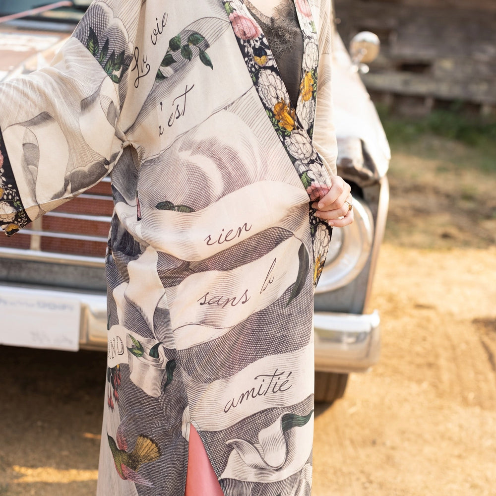 
                  
                    Clasped hands, radiant sun rays, and blooming florals in a joyful Victorian collage on our full-length Take My Hand Opera Duster
                  
                