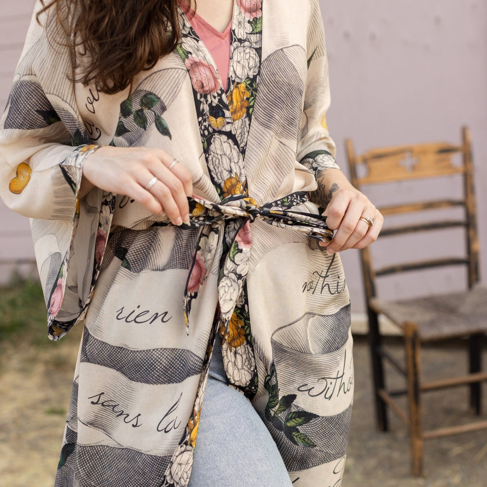 
                  
                    Clasped hands, radiant sun rays, and blooming florals in a joyful Victorian collage on our full-length Take My Hand Opera Duster
                  
                