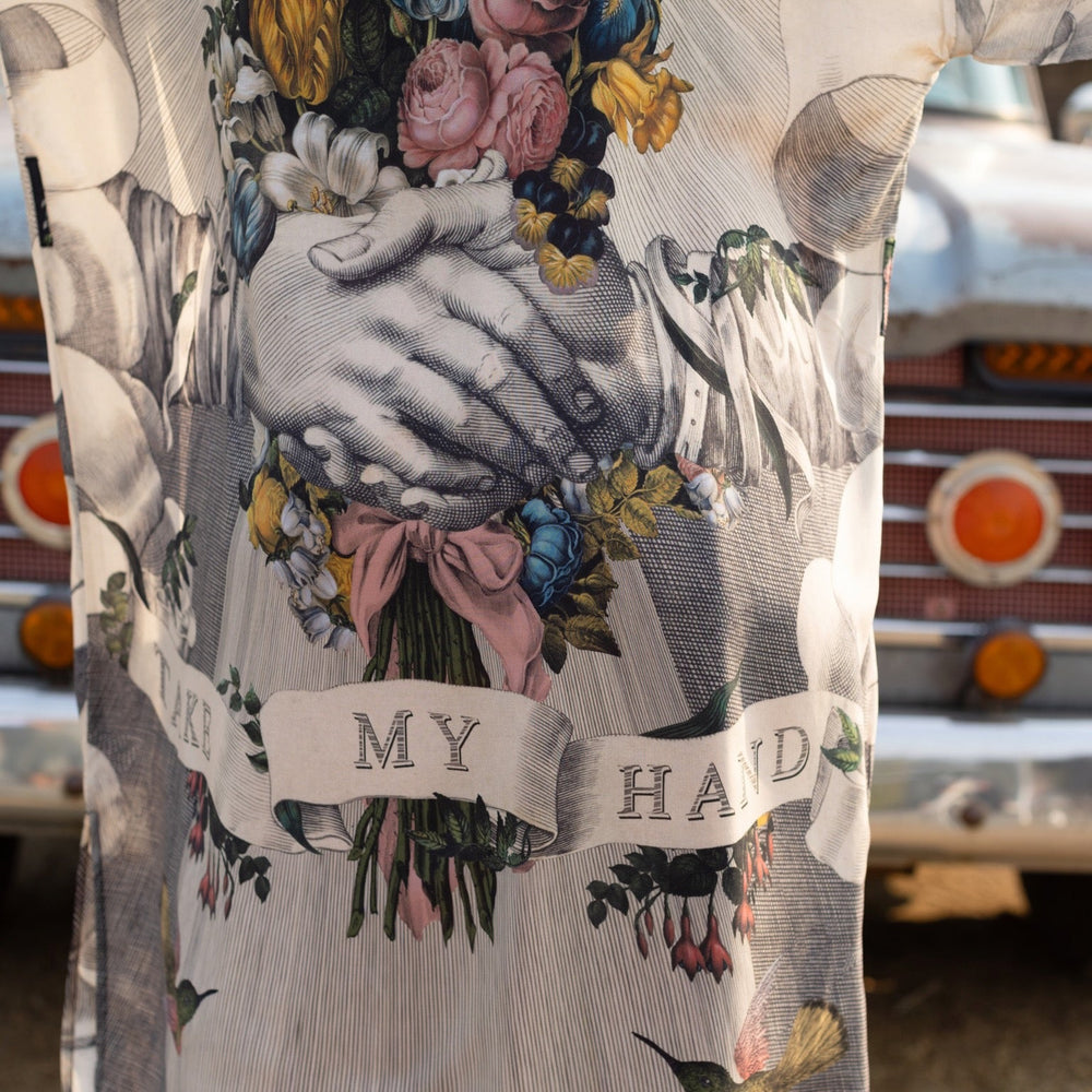 
                  
                    Clasped hands, radiant sun rays, and blooming florals in a joyful Victorian collage on our full-length Take My Hand Opera Duster
                  
                