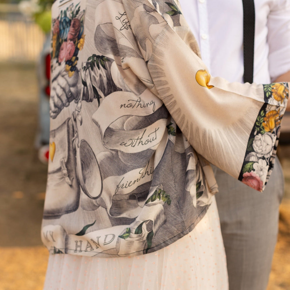 
                  
                    A joyful blend of 17th-century engravings, painted hearts, and hand-coloured florals on our cropped Take My Hand Pixie duster kimono – Market of Stars
                  
                