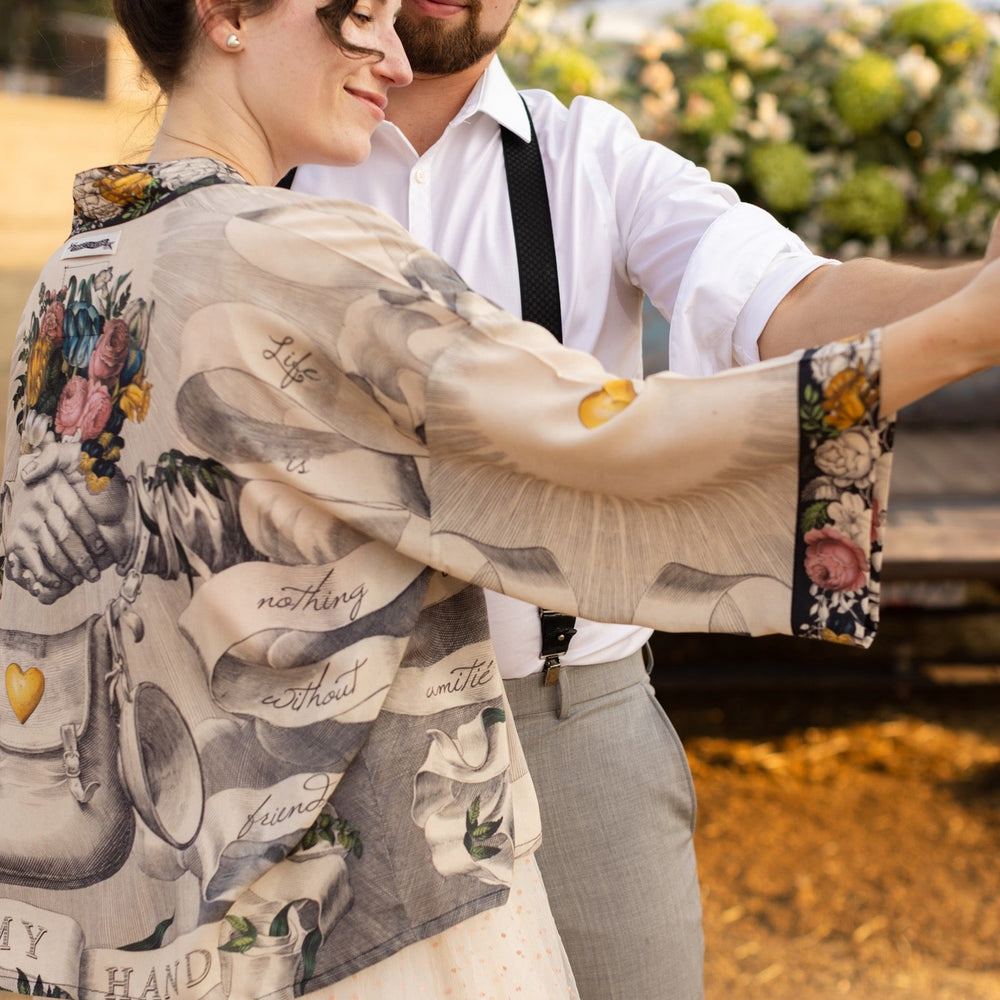 
                  
                    A joyful blend of 17th-century engravings, painted hearts, and hand-coloured florals on our cropped Take My Hand Pixie duster kimono – Market of Stars
                  
                