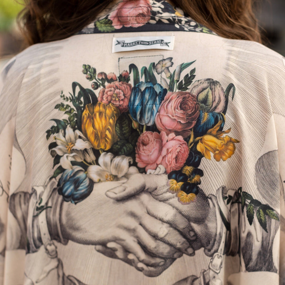 
                  
                    A joyful blend of 17th-century engravings, painted hearts, and hand-coloured florals on our cropped Take My Hand Pixie duster kimono – Market of Stars
                  
                