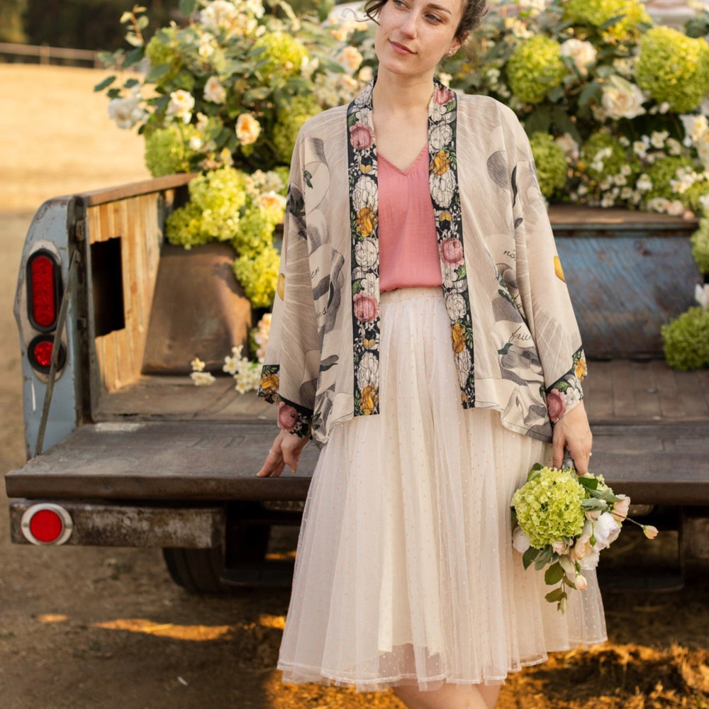 
                  
                    A joyful blend of 17th-century engravings, painted hearts, and hand-coloured florals on our cropped Take My Hand Pixie duster kimono – Market of Stars
                  
                