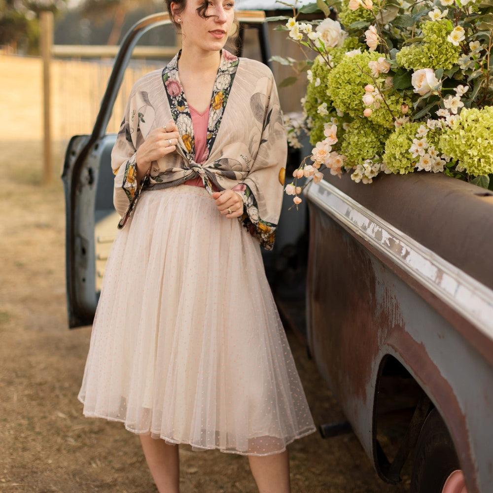 
                  
                    A joyful blend of 17th-century engravings, painted hearts, and hand-coloured florals on our cropped Take My Hand Pixie duster kimono – Market of Stars
                  
                