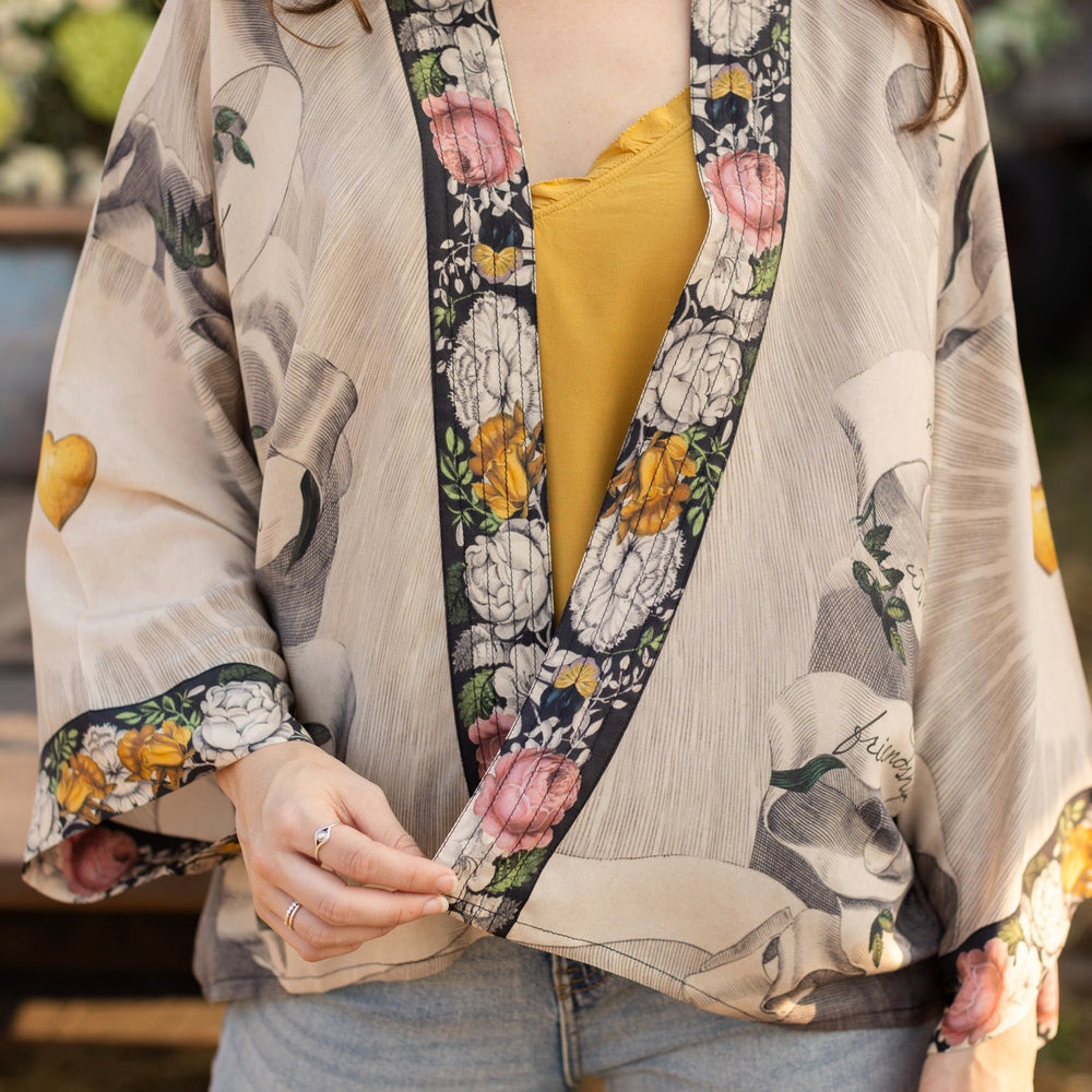 
                  
                    A joyful blend of 17th-century engravings, painted hearts, and hand-coloured florals on our cropped Take My Hand Pixie duster kimono – Market of Stars
                  
                
