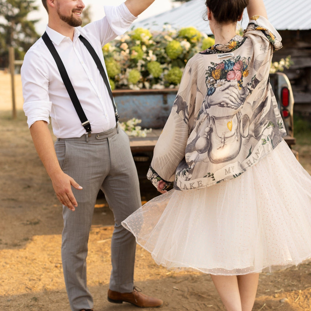 
                  
                    A joyful blend of 17th-century engravings, painted hearts, and hand-coloured florals on our cropped Take My Hand Pixie duster kimono – Market of Stars
                  
                
