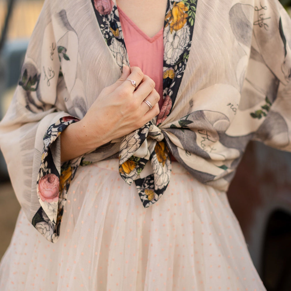 
                  
                    A joyful blend of 17th-century engravings, painted hearts, and hand-coloured florals on our cropped Take My Hand Pixie duster kimono – Market of Stars
                  
                