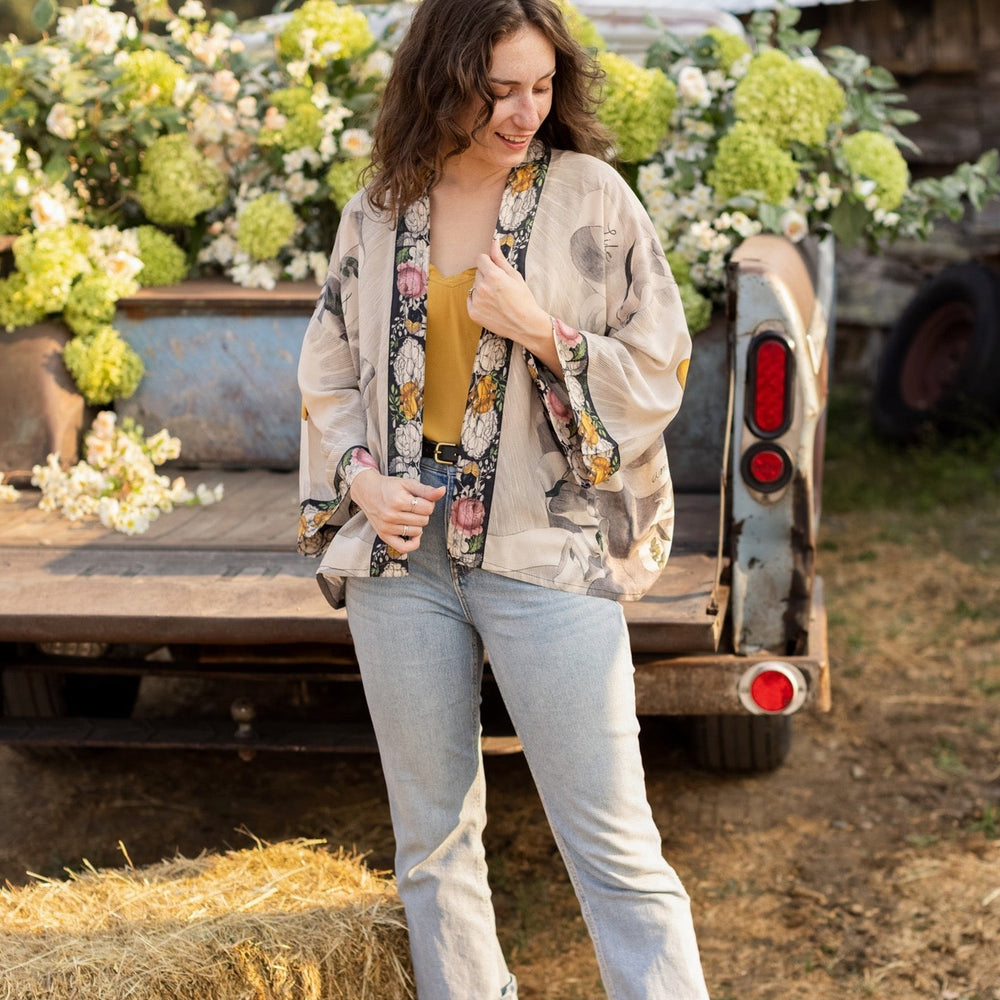 
                  
                    A joyful blend of 17th-century engravings, painted hearts, and hand-coloured florals on our cropped Take My Hand Pixie duster kimono – Market of Stars
                  
                