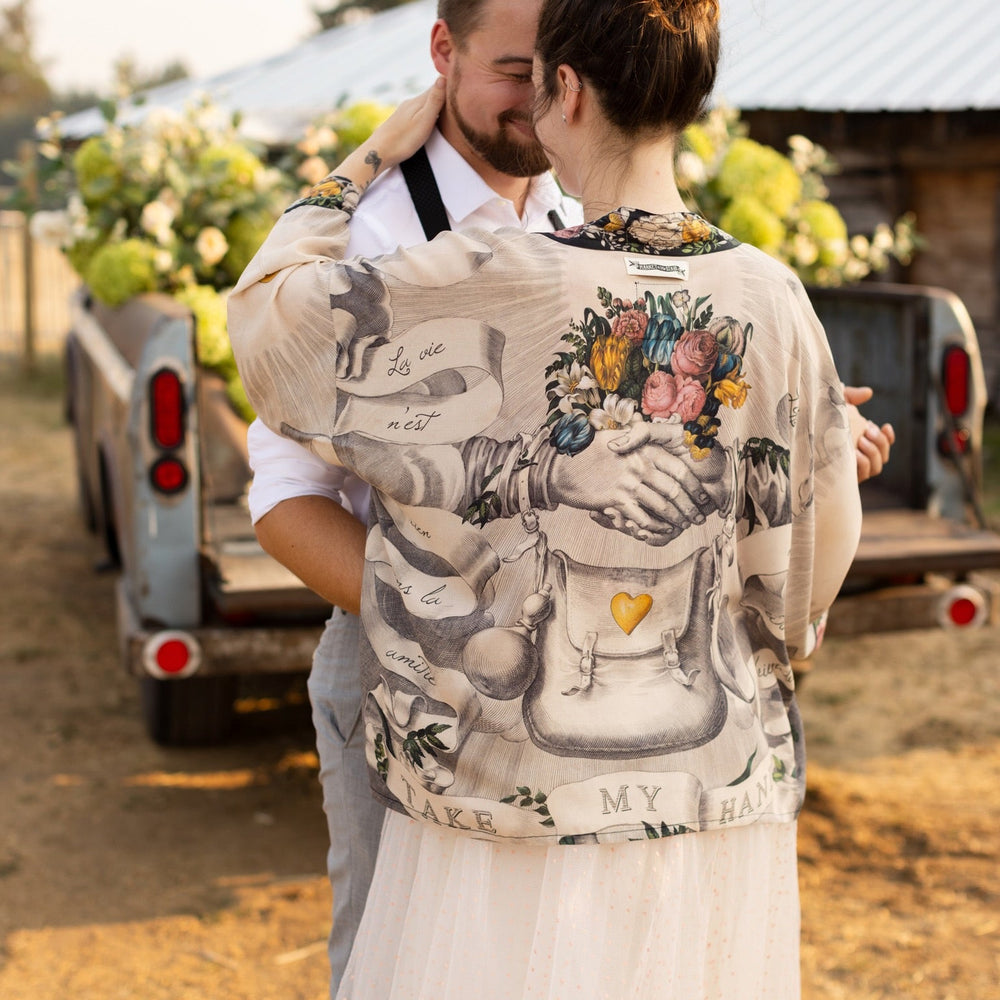 
                  
                    A joyful blend of 17th-century engravings, painted hearts, and hand-coloured florals on our cropped Take My Hand Pixie duster kimono – Market of Stars
                  
                