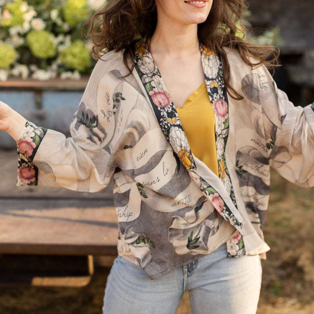 
                  
                    A joyful blend of 17th-century engravings, painted hearts, and hand-coloured florals on our cropped Take My Hand Pixie duster kimono – Market of Stars
                  
                