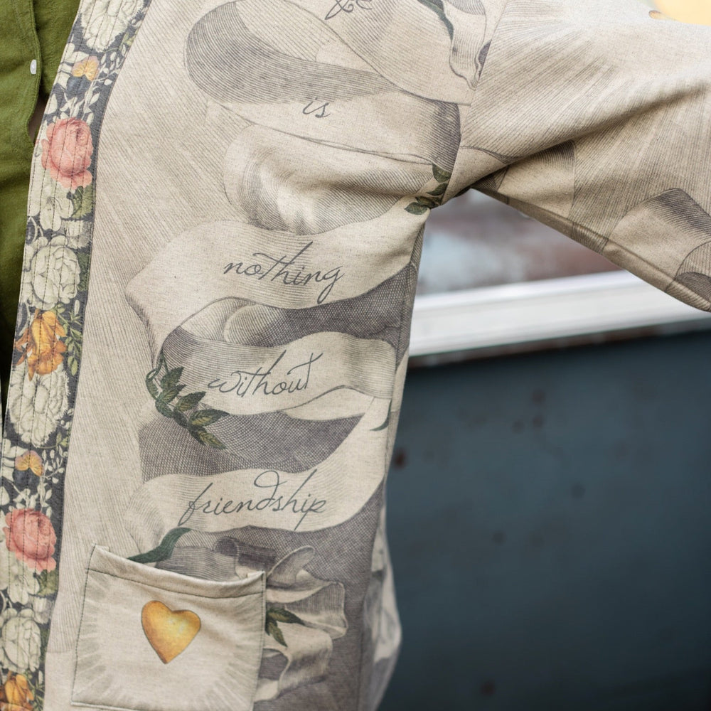 
                  
                    A cozy cardigan lined in fleece featuring Victorian collage artwork and the phrase “Life is nothing without friendship” – Market of Stars
                  
                