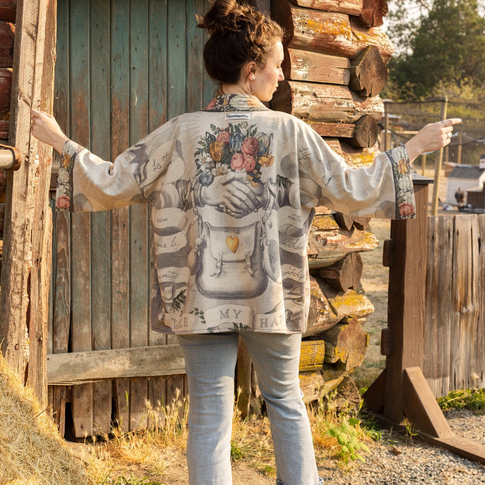 
                  
                    A cozy cardigan lined in fleece featuring Victorian collage artwork and the phrase “Life is nothing without friendship” – Market of Stars
                  
                