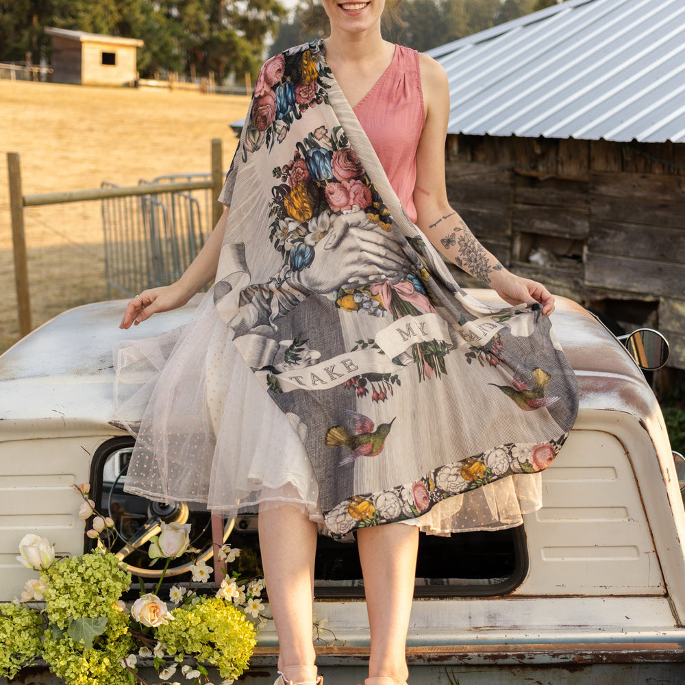 Model wearing Take My Hand scarf with 1600s hand engraving of clasped hands, a painted heart, florals and sun rays – Market of Stars