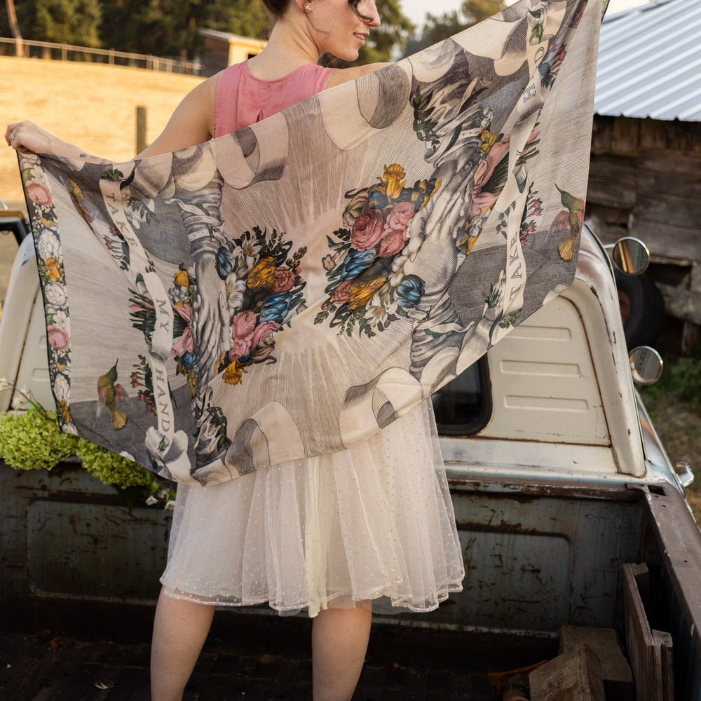 Model wearing Take My Hand scarf with 1600s hand engraving of clasped hands, a painted heart, florals and sun rays – Market of Stars