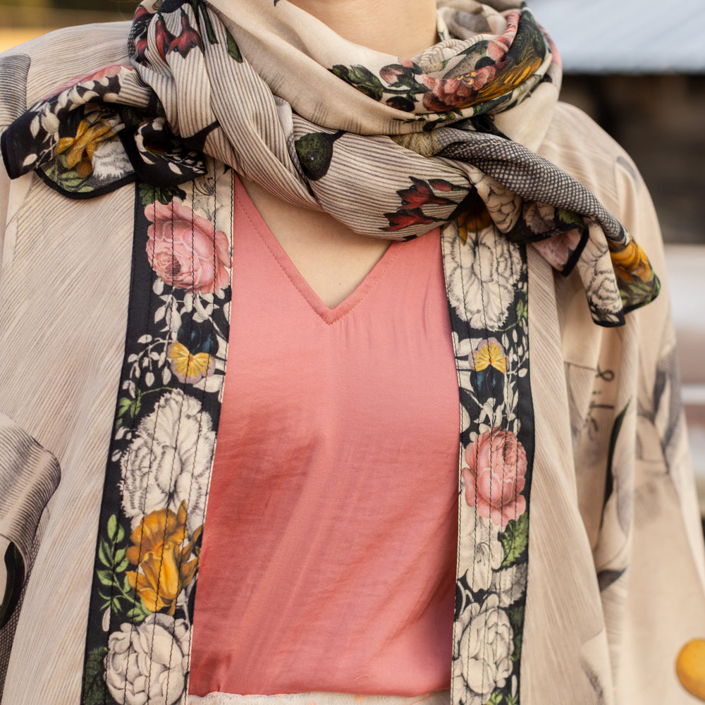 
                  
                    Model wearing Take My Hand scarf with 1600s hand engraving of clasped hands, a painted heart, florals and sun rays – Market of Stars
                  
                