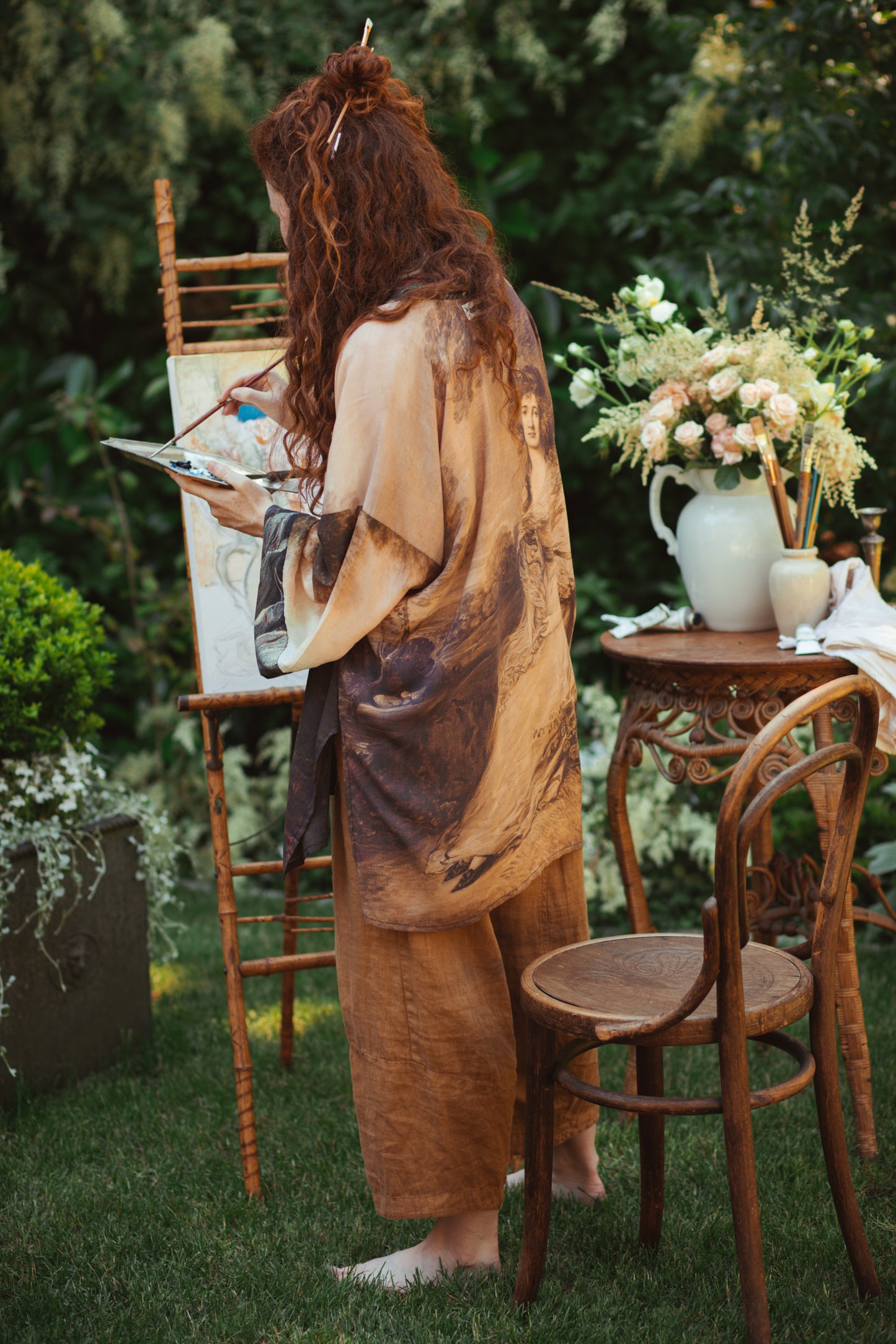 Model wearing The Artist kimono-style duster featuring antique paintings, botanical floral trim, and a radiant golden sun – Market of Stars