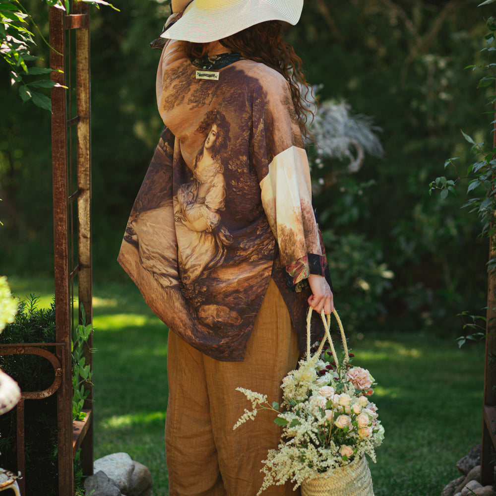 
                  
                    Model wearing The Artist kimono-style duster featuring antique paintings, botanical floral trim, and a radiant golden sun – Market of Stars
                  
                