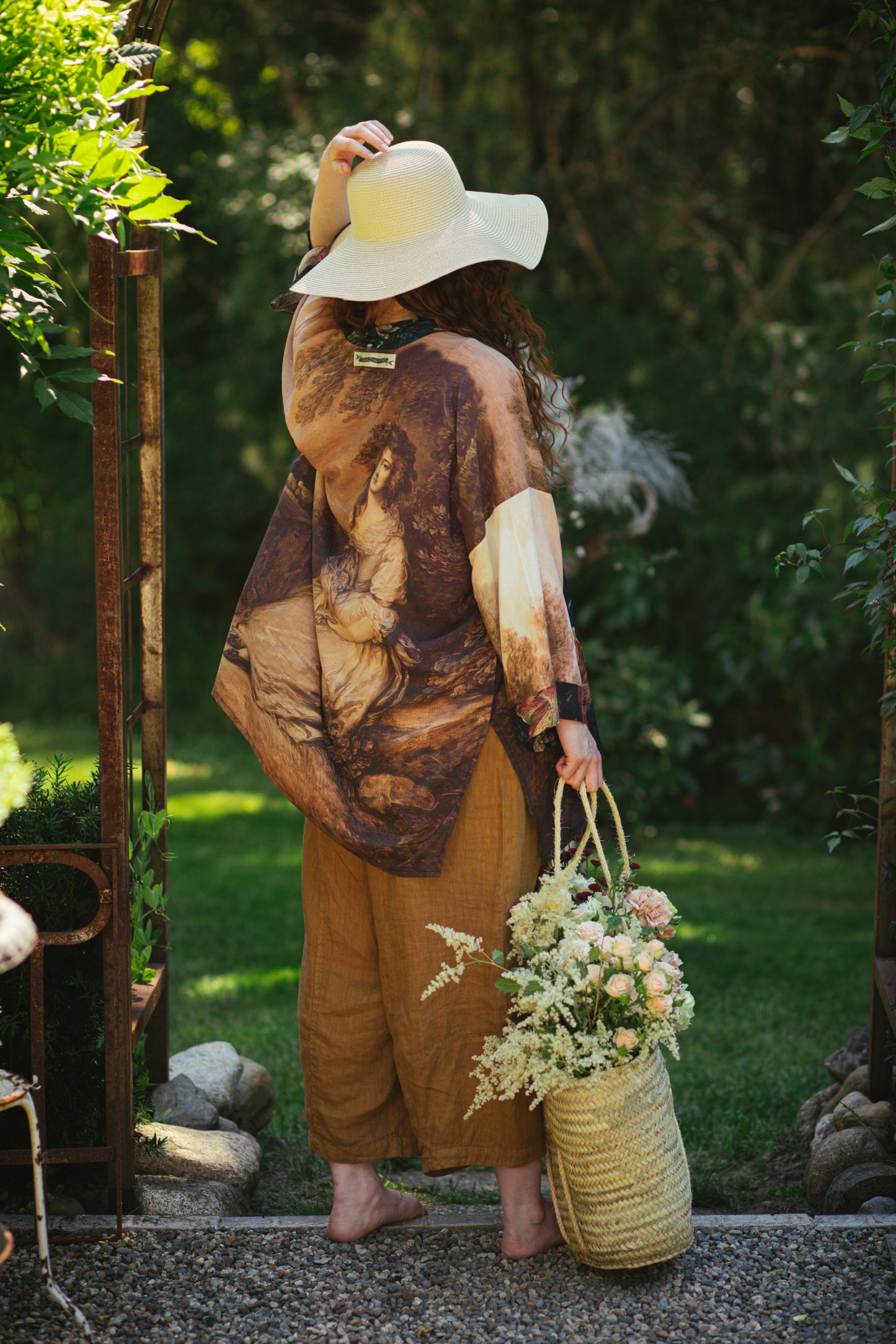 Model wearing The Artist kimono-style duster featuring antique paintings, botanical floral trim, and a radiant golden sun – Market of Stars