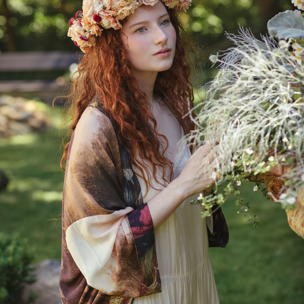 
                  
                    Model wearing The Artist kimono-style duster featuring antique paintings, botanical floral trim, and a radiant golden sun – Market of Stars
                  
                