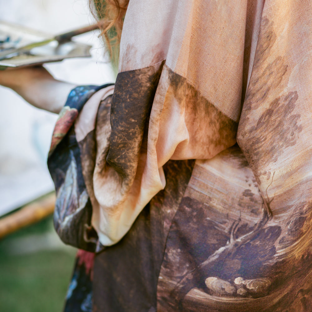 
                  
                    Model wearing The Artist kimono-style duster featuring antique paintings, botanical floral trim, and a radiant golden sun – Market of Stars
                  
                