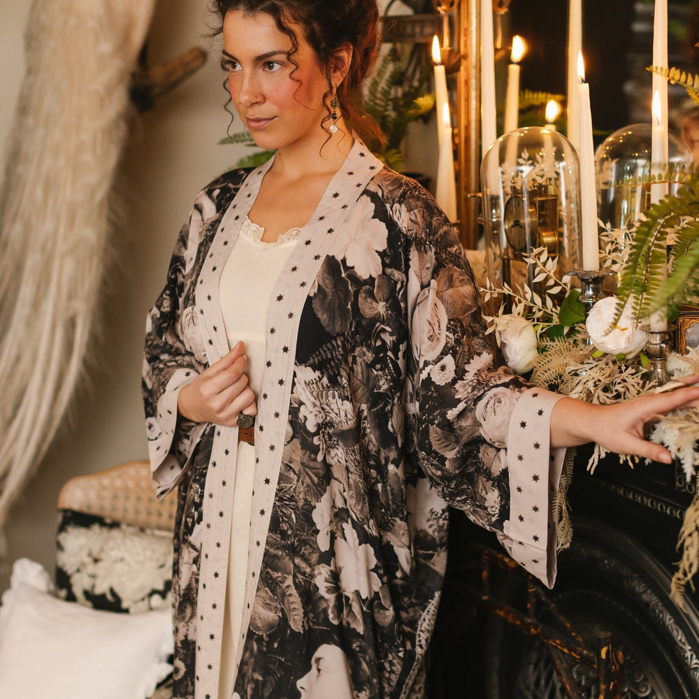 
                  
                    Model wearing Looking Glass Opera Robe featuring grown-up Alice Liddell, Victorian botanicals, and celestial star and moon accents inspired by Wonderland – Market of Stars.
                  
                