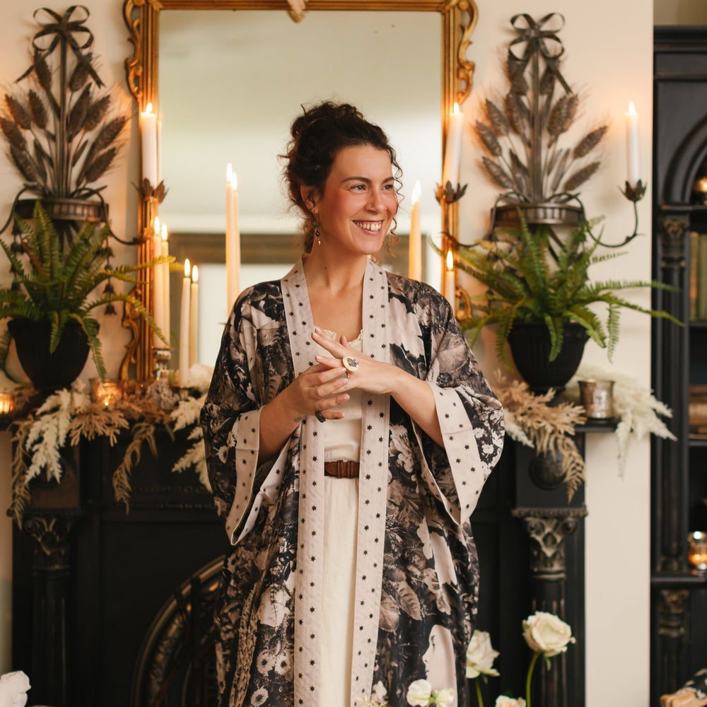 
                  
                    Model wearing Looking Glass Opera Robe featuring grown-up Alice Liddell, Victorian botanicals, and celestial star and moon accents inspired by Wonderland – Market of Stars.
                  
                