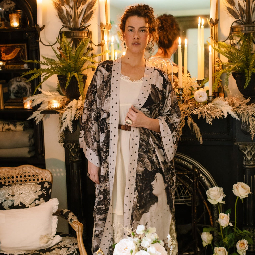 
                  
                    Model wearing Looking Glass Opera Robe featuring grown-up Alice Liddell, Victorian botanicals, and celestial star and moon accents inspired by Wonderland – Market of Stars.
                  
                