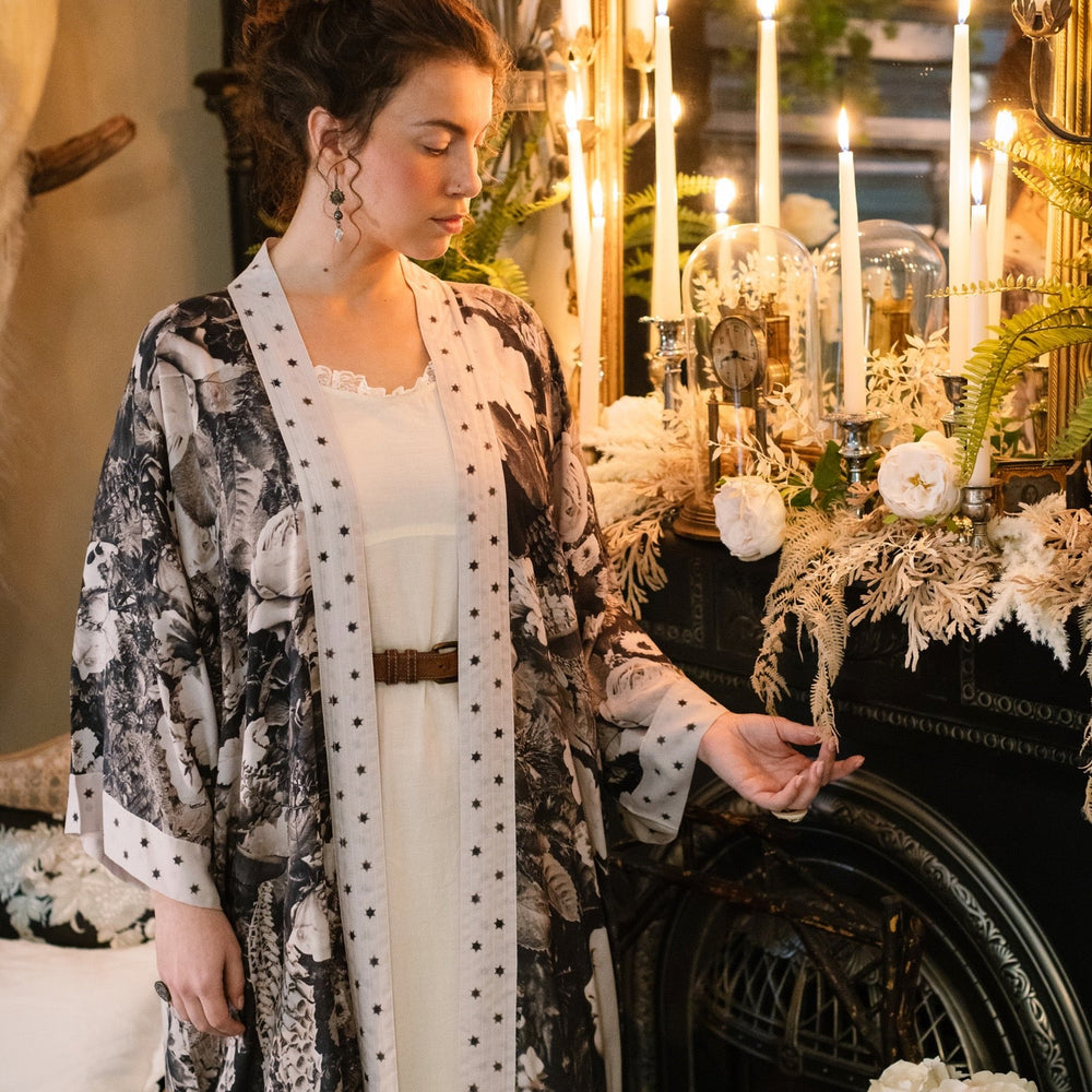 
                  
                    Model wearing Looking Glass Opera Robe featuring grown-up Alice Liddell, Victorian botanicals, and celestial star and moon accents inspired by Wonderland – Market of Stars.
                  
                