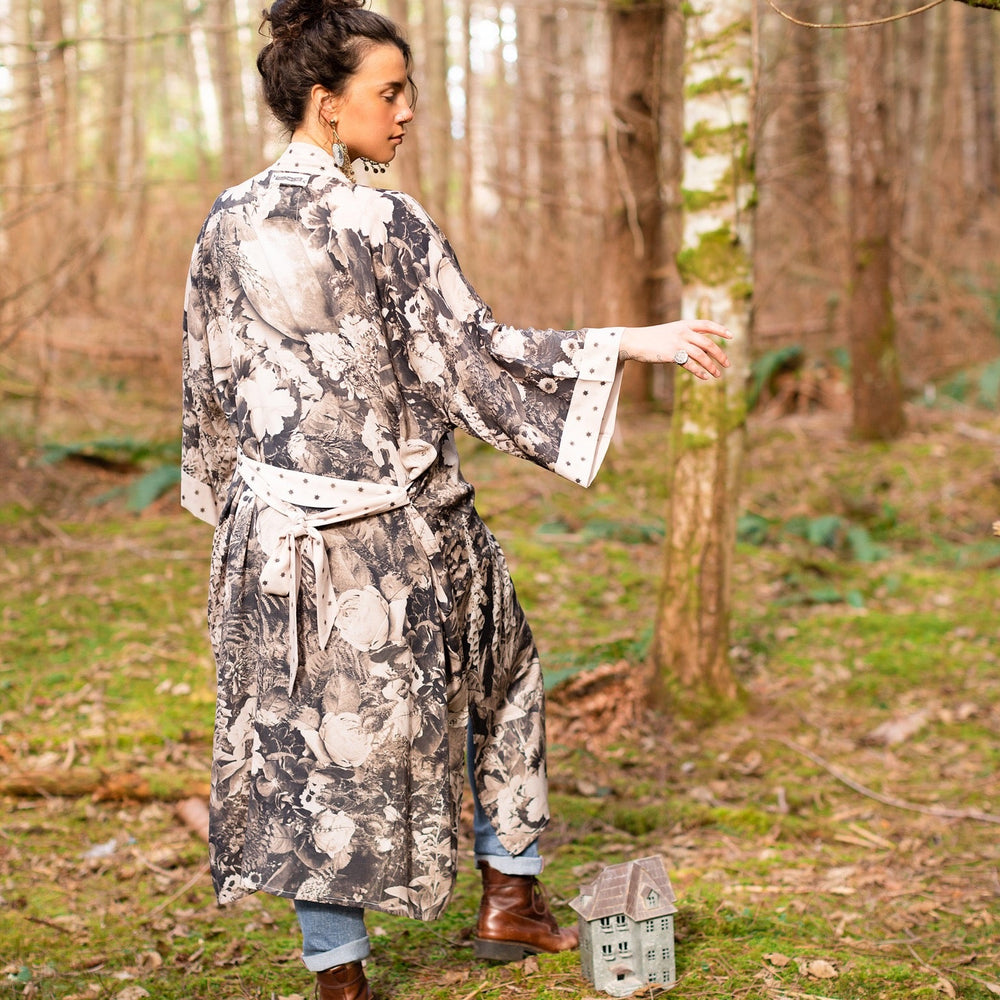 
                  
                    Model wearing Looking Glass Opera Robe featuring grown-up Alice Liddell, Victorian botanicals, and celestial star and moon accents inspired by Wonderland – Market of Stars.
                  
                
