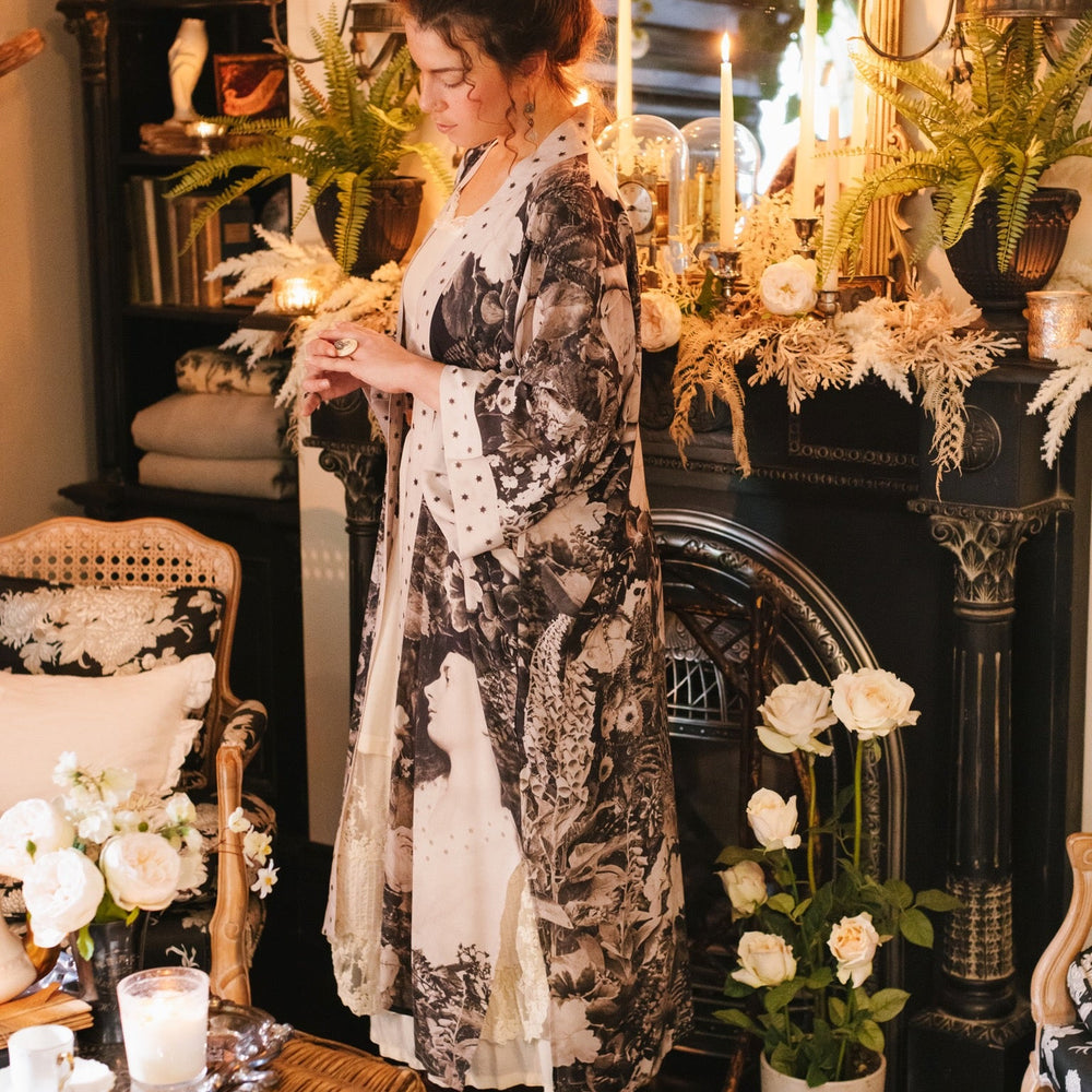 
                  
                    Model wearing Looking Glass Opera Robe featuring grown-up Alice Liddell, Victorian botanicals, and celestial star and moon accents inspired by Wonderland – Market of Stars.
                  
                