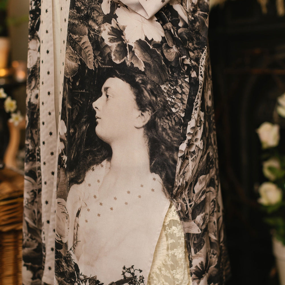 
                  
                    Model wearing Looking Glass Opera Robe featuring grown-up Alice Liddell, Victorian botanicals, and celestial star and moon accents inspired by Wonderland – Market of Stars.
                  
                