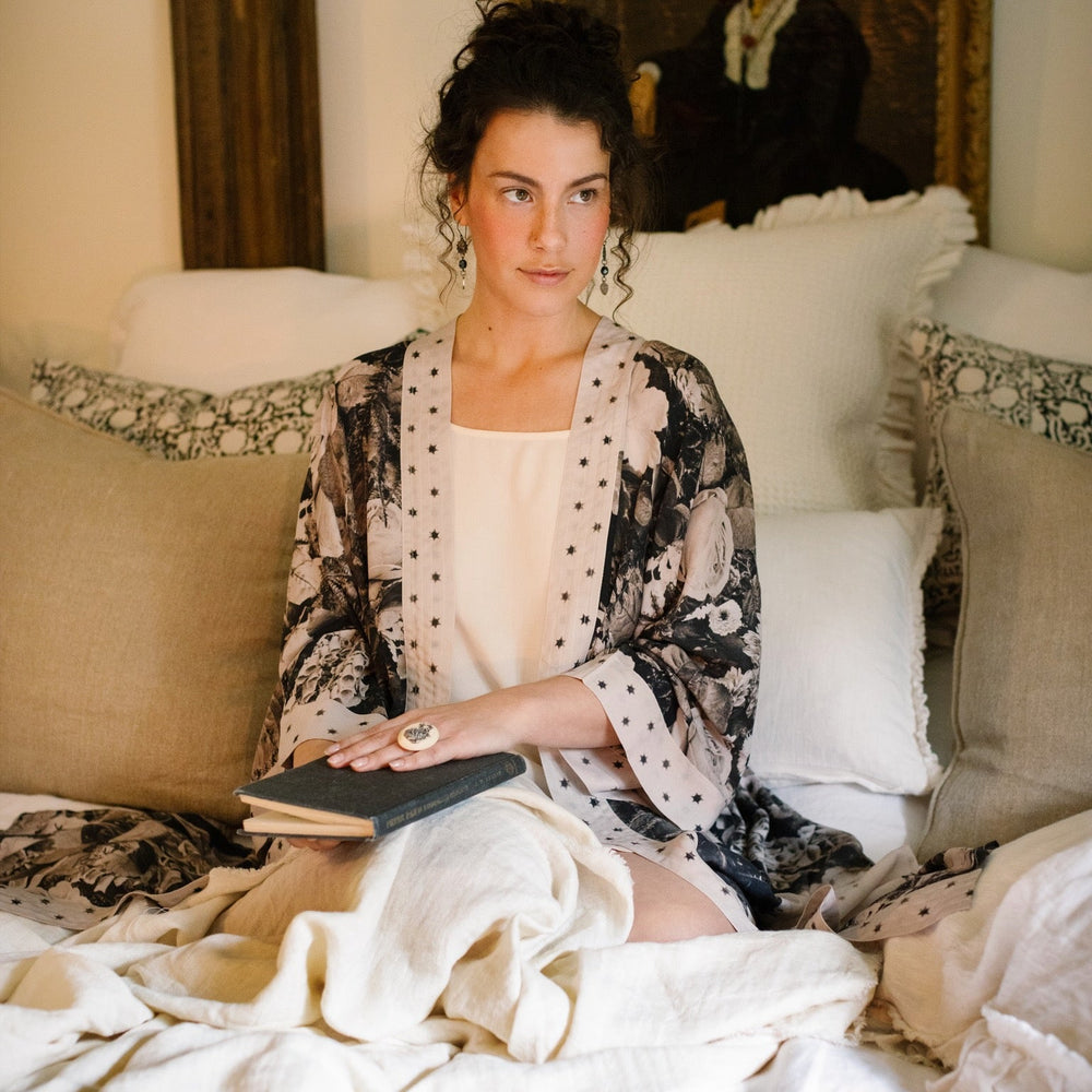 
                  
                    Model wearing Looking Glass Opera Robe featuring grown-up Alice Liddell, Victorian botanicals, and celestial star and moon accents inspired by Wonderland – Market of Stars.
                  
                