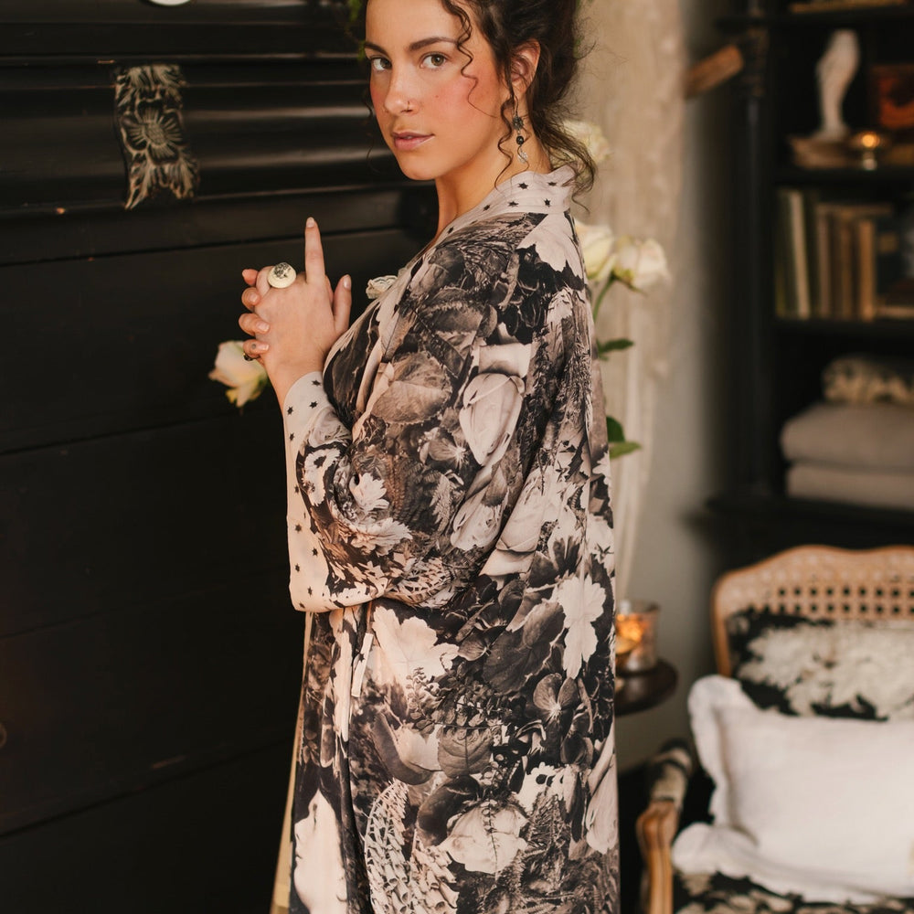 
                  
                    Model wearing Looking Glass Opera Robe featuring grown-up Alice Liddell, Victorian botanicals, and celestial star and moon accents inspired by Wonderland – Market of Stars.
                  
                