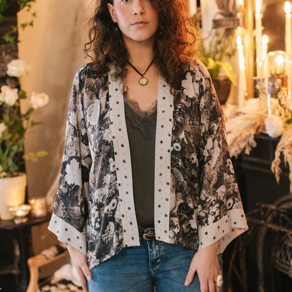 
                  
                    Model wearing Looking Glass Cropped Kimono featuring grown-up Alice Liddell, rare Victorian botanicals, and celestial star and moon accents inspired by Wonderland – Market of Stars.
                  
                