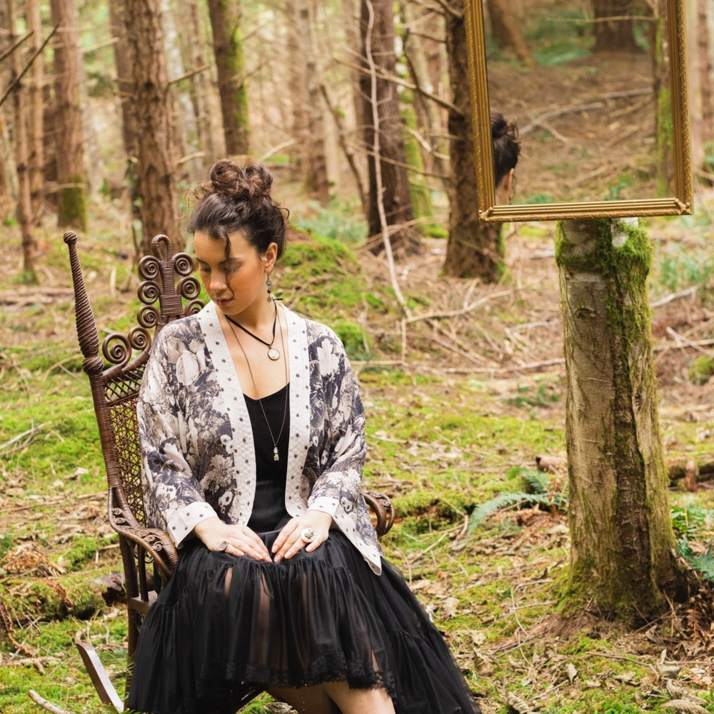 
                  
                    Model wearing Looking Glass Cropped Kimono featuring grown-up Alice Liddell, rare Victorian botanicals, and celestial star and moon accents inspired by Wonderland – Market of Stars.
                  
                