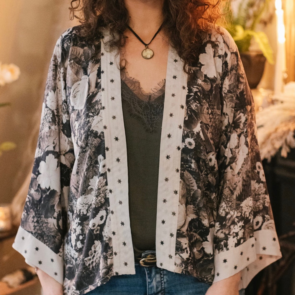 
                  
                    Model wearing Looking Glass Cropped Kimono featuring grown-up Alice Liddell, rare Victorian botanicals, and celestial star and moon accents inspired by Wonderland – Market of Stars.
                  
                