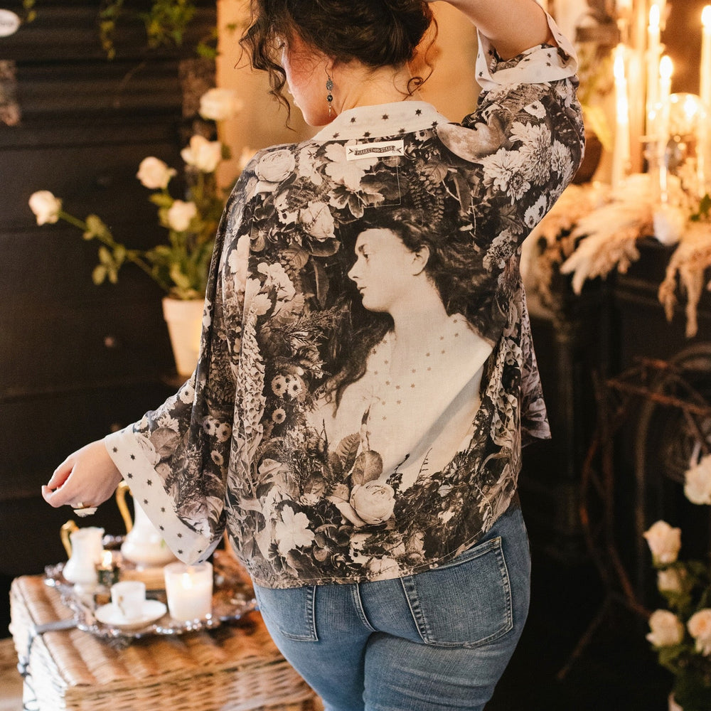 
                  
                    Model wearing Looking Glass Cropped Kimono featuring grown-up Alice Liddell, rare Victorian botanicals, and celestial star and moon accents inspired by Wonderland – Market of Stars.
                  
                
