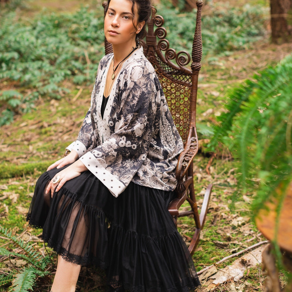 
                  
                    Model wearing Looking Glass Cropped Kimono featuring grown-up Alice Liddell, rare Victorian botanicals, and celestial star and moon accents inspired by Wonderland – Market of Stars.
                  
                