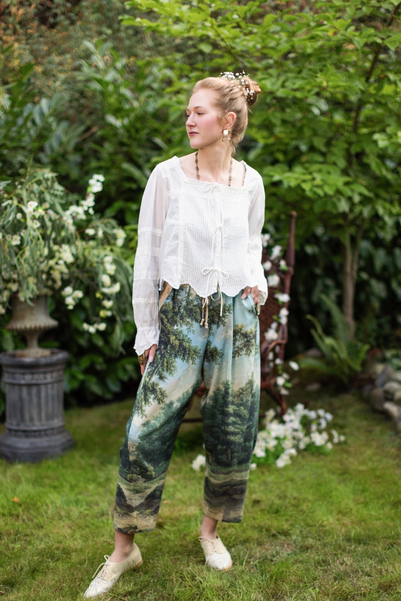 Model wearing a cropped length linen blend pant ft. vintage artwork & unicorn lorn set against a mossy-green landscape — a romantic piece for the modern dreamer - Market of Stars