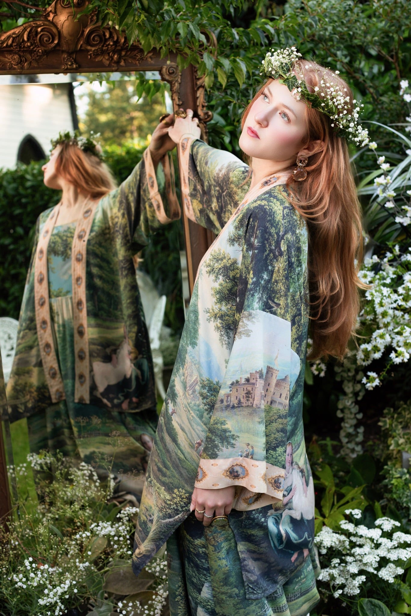 Model wearing a mid-length duster ft. vintage artwork & unicorn lorn set against a mossy-green landscape — a romantic piece for the modern dreamer - Market of Stars