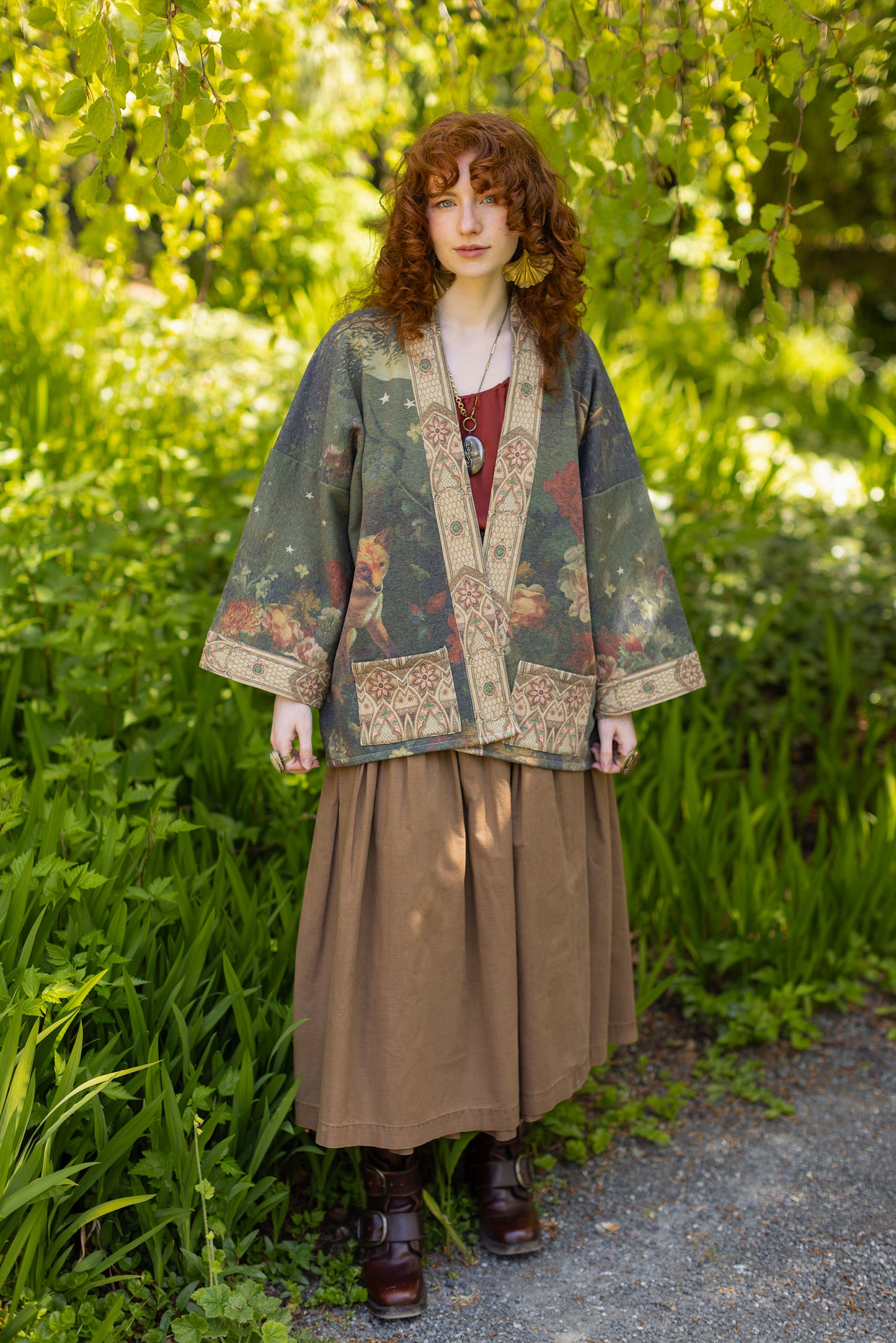 Model wearing a cozy cardigan lined with fleece featuring florals from centuries-old paintings and Rosetti’s iconic portrait of Joan of Arc - Market of Stars
