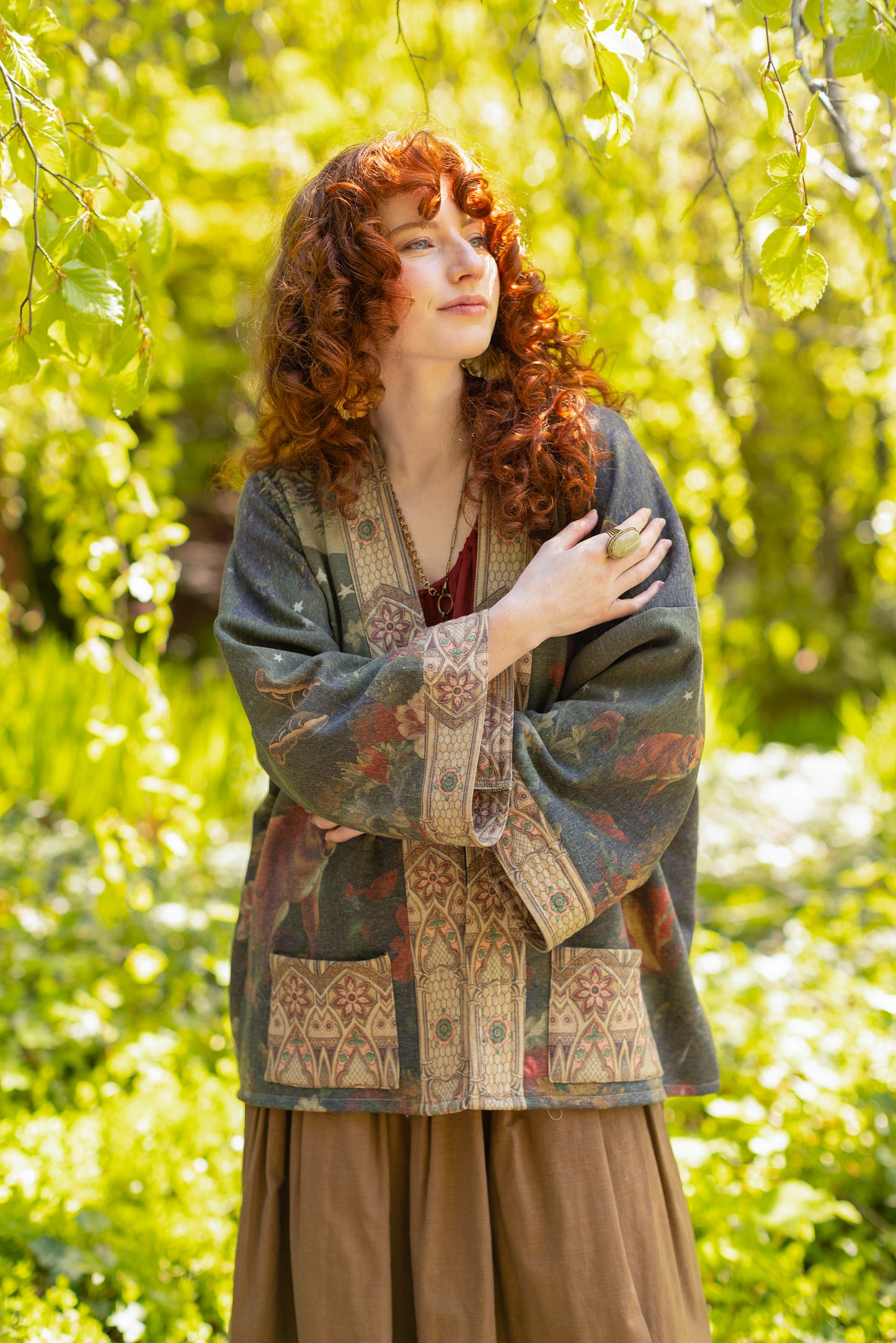 Model wearing a cozy cardigan lined with fleece featuring florals from centuries-old paintings and Rosetti’s iconic portrait of Joan of Arc - Market of Stars