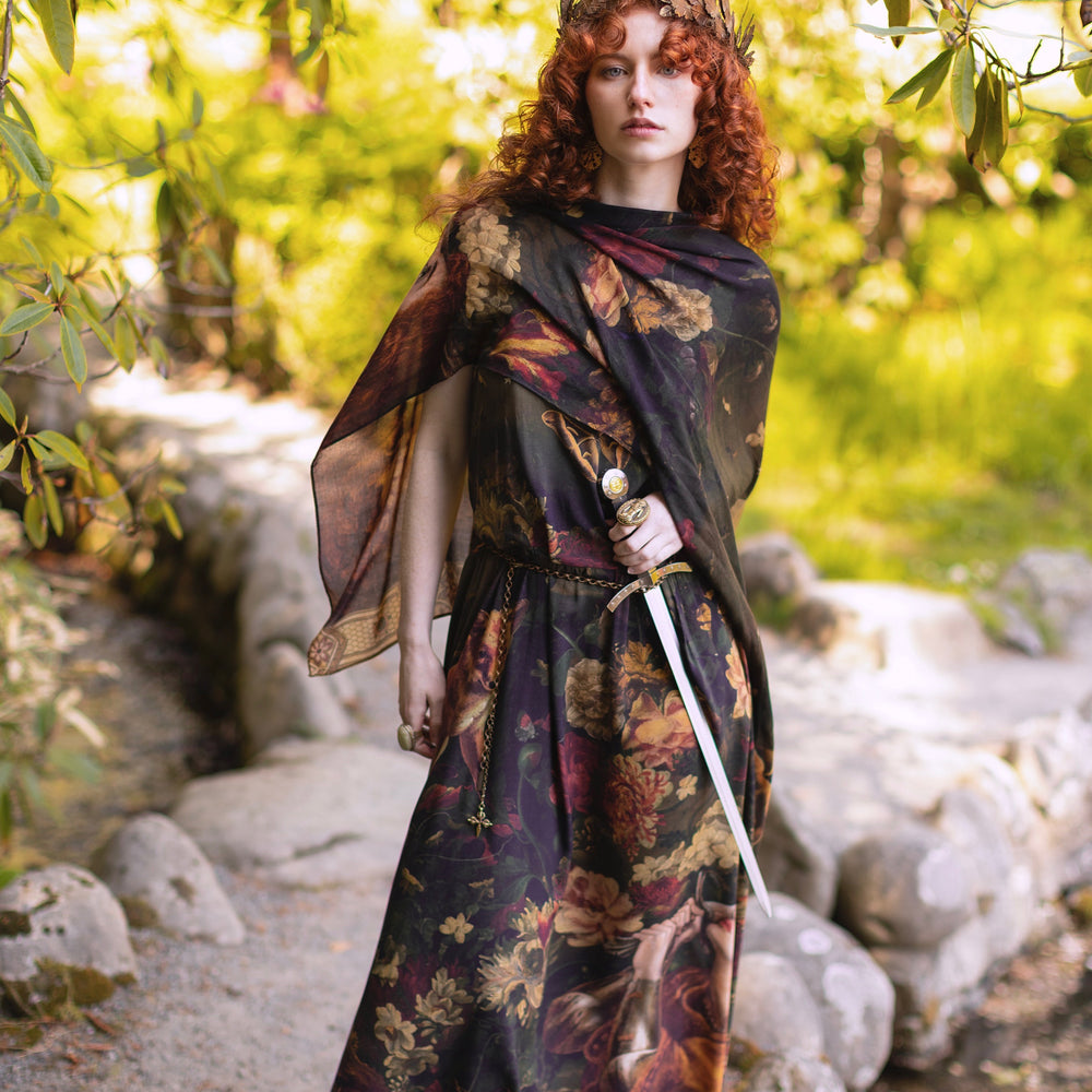 
                  
                    Model wearing a bamboo-viscose scarf featuring florals from centuries-old paintings and Rosetti’s iconic portrait of Joan of Arc - Market of Stars
                  
                