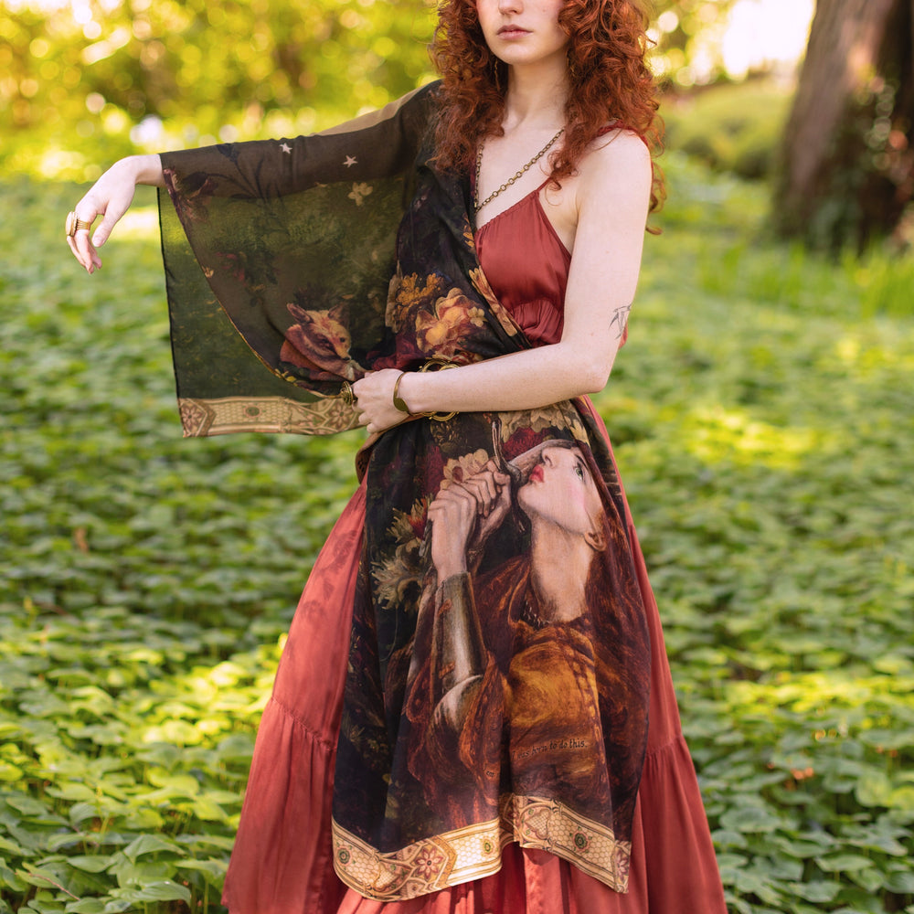 
                  
                    Model wearing a bamboo-viscose scarf featuring florals from centuries-old paintings and Rosetti’s iconic portrait of Joan of Arc - Market of Stars
                  
                