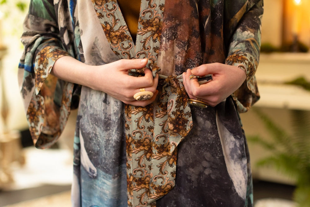 
                  
                    Model wearing the Theatre of Dreams Opera Duster featuring whimsical birds, love letters, and richly painted curtains by artist Jennifer Lanne – Market of Stars
                  
                