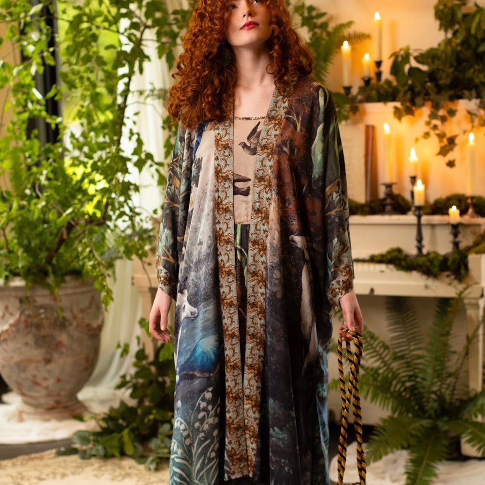 
                  
                    Model wearing the Theatre of Dreams Opera Duster featuring whimsical birds, love letters, and richly painted curtains by artist Jennifer Lanne – Market of Stars
                  
                