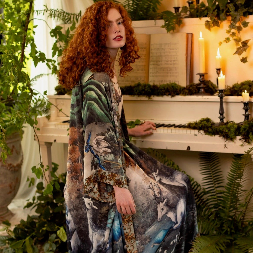 
                  
                    Model wearing the Theatre of Dreams Opera Duster featuring whimsical birds, love letters, and richly painted curtains by artist Jennifer Lanne – Market of Stars
                  
                