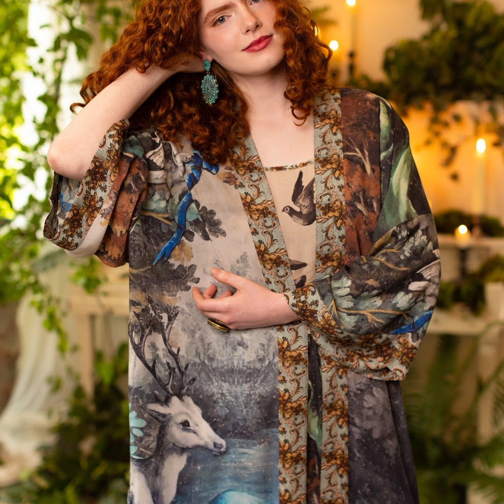 
                  
                    Model wearing the Theatre of Dreams Opera Duster featuring whimsical birds, love letters, and richly painted curtains by artist Jennifer Lanne – Market of Stars
                  
                